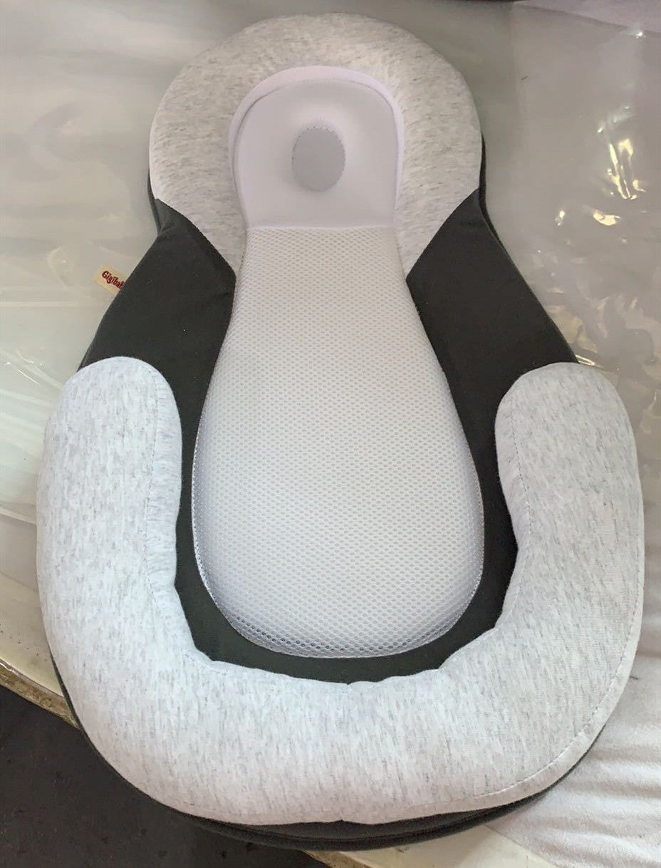 baby sleeping in soft baby lounger travel bed