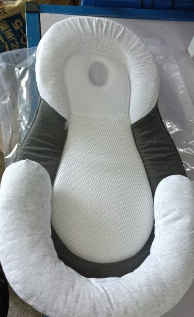 baby sleeping in soft baby lounger travel bed